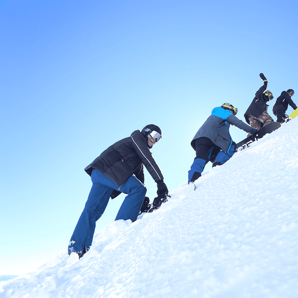 Shaun Vine in Snowboarding gear climbing a mountain with friends